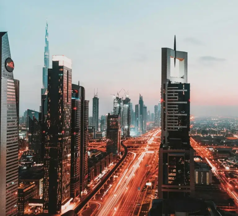 Dusk cityscape with skyscrapers and light trails.